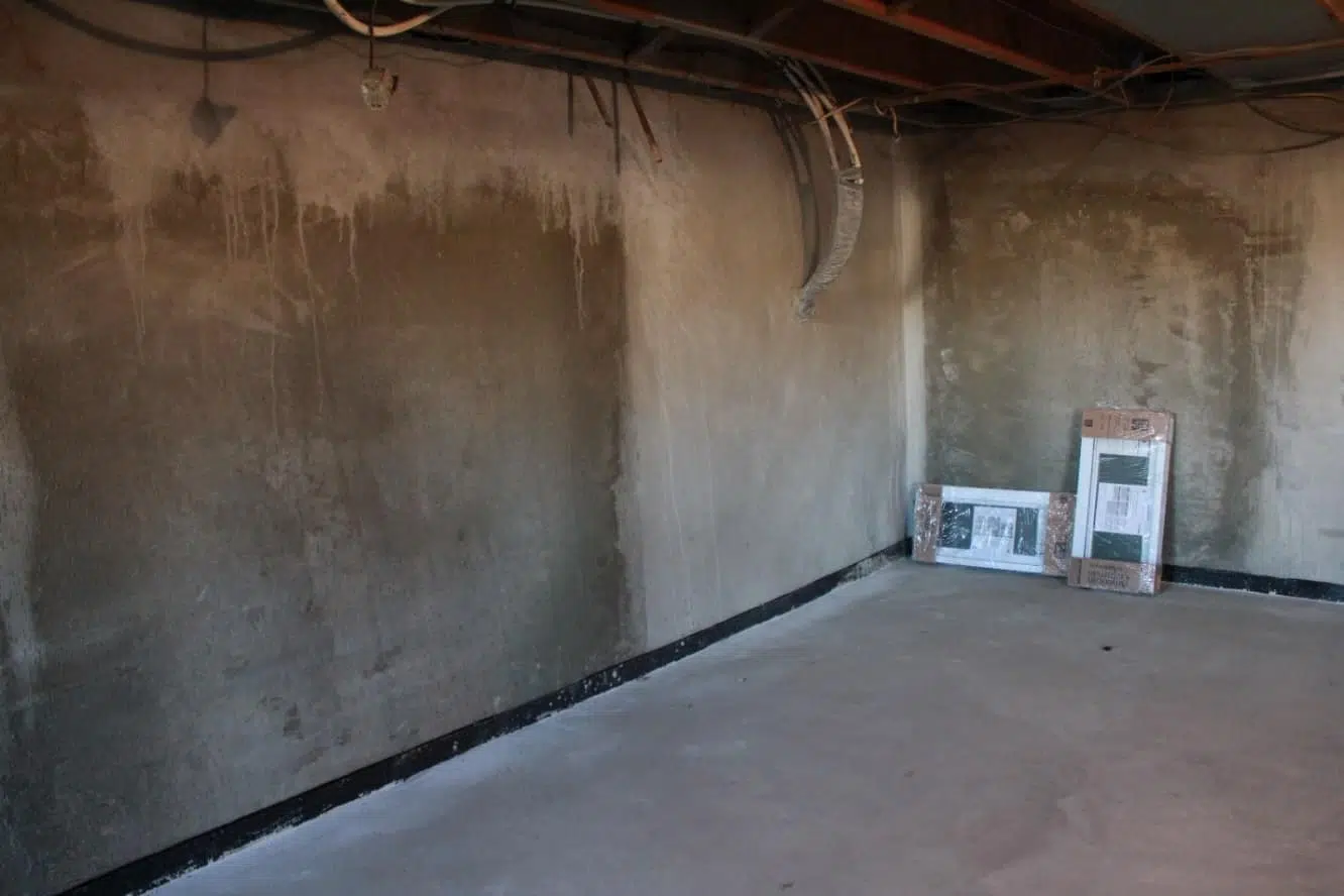 a room with a concrete wall and a few boxes on the floor