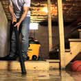 a man is using a vacuum cleaner to clean the floor in a garage .