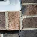 a close up of a brick wall with a window in the background .