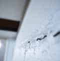 a close up of a white wall with a few holes on it .