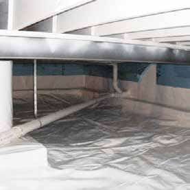 a crawl space filled with plastic and pipes under a house .