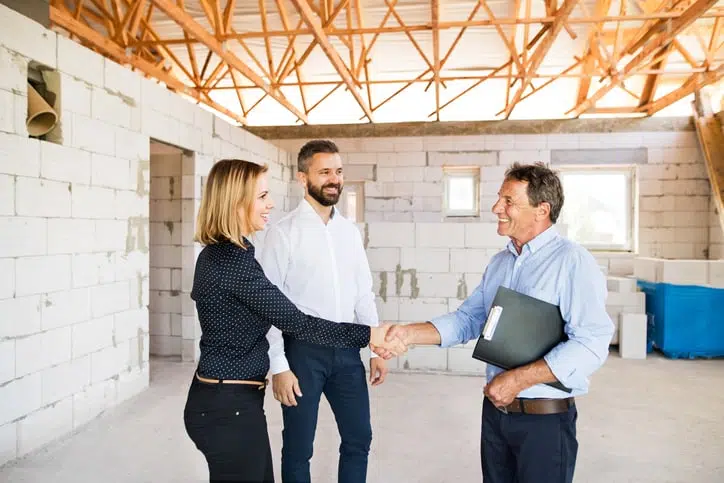a man and woman shaking hands with a man holding a clipboard