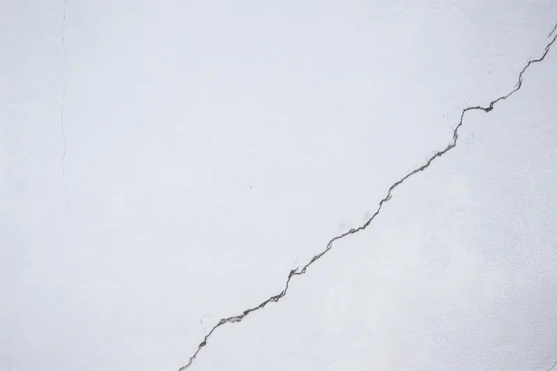 a close up of a white wall with a large crack