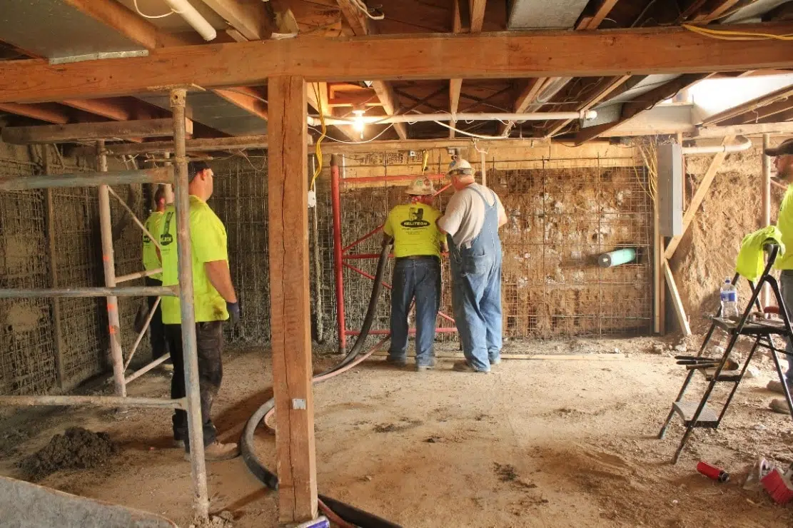 a group of construction workers wearing overalls and hard hats are working on a wall