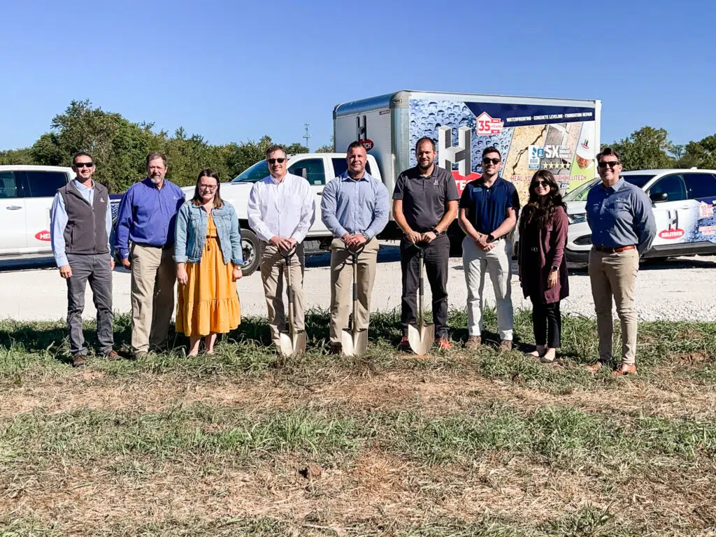 a group of helitech employees with a shovel