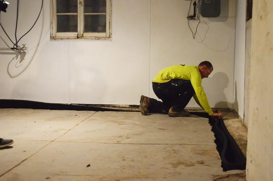 a man kneeling down in a room with a yellow shirt