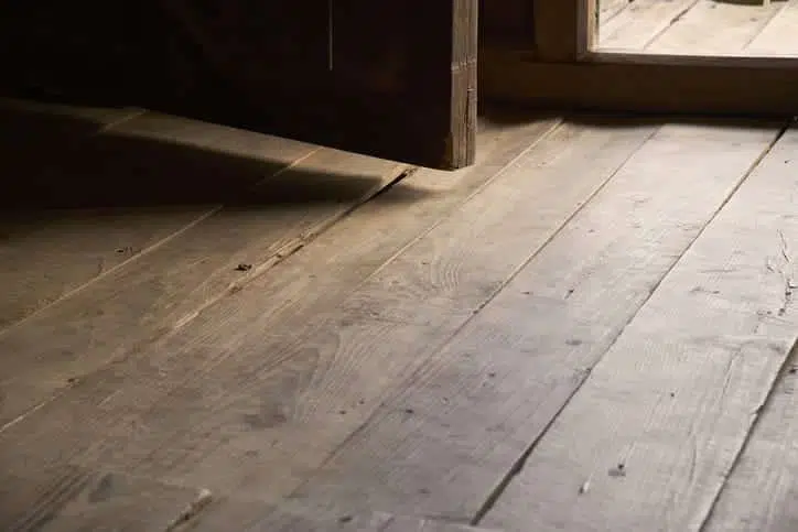 a close up of a wooden floor with a door open .