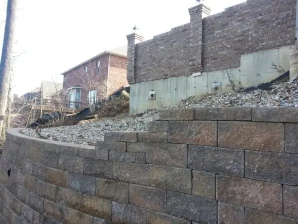 a brick wall with a house in the background