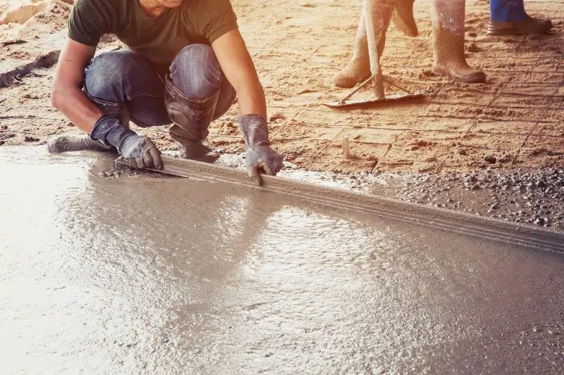 a man is working on a concrete floor with a trowel