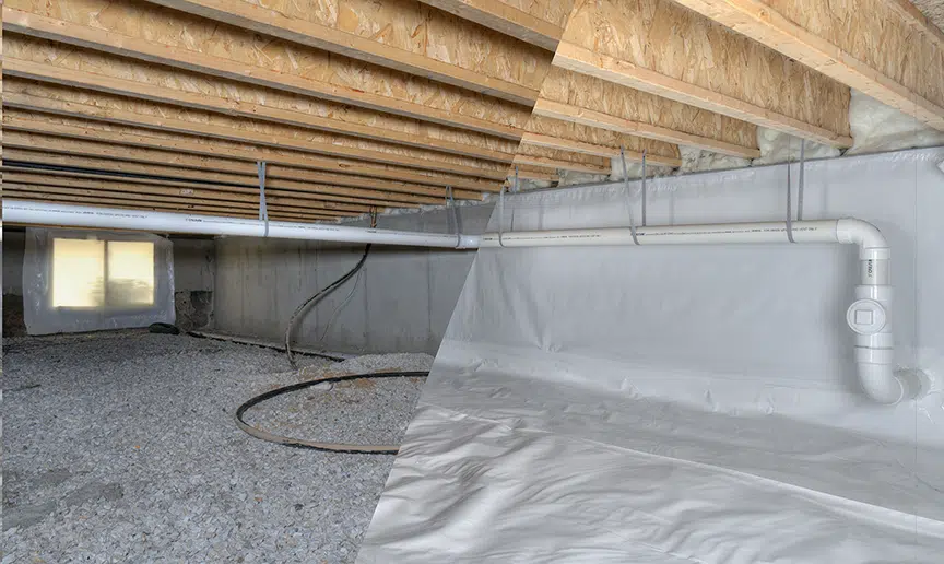 a basement with a white pipe that says ' drain ' on it