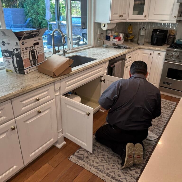 Liquid Plumbing tech installing a garbage disposal in Villa Park, CA 92861